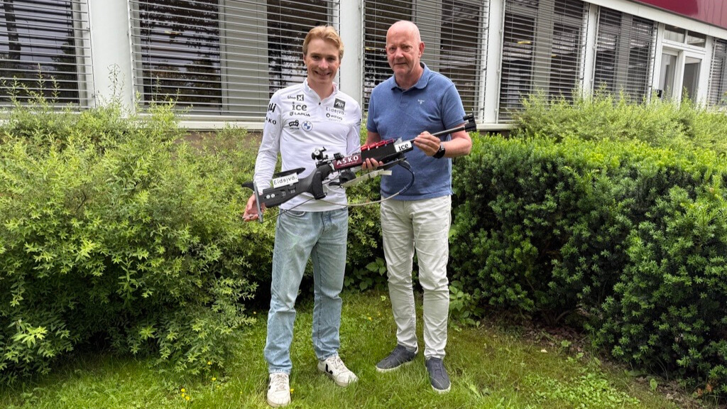 Isak Frey og Tore Bekken står foran ASKO-bygg i Oslo og holder et skiskyttergevær